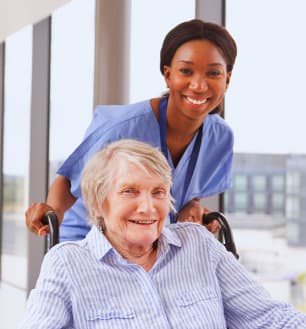 female caregiver and senior woman smiling