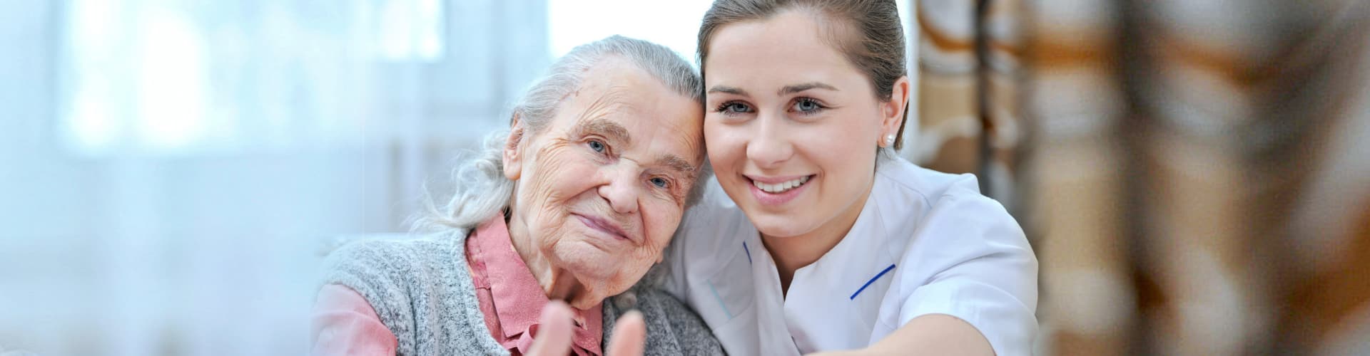 senior woman and female caregiver doing thumbs up