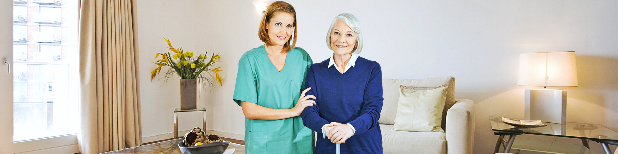 female caregiver and senior woman smiling